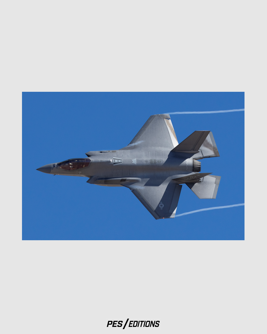 An action-packed, close-up photograph of a U.S. Air Force F-35A Lightning II stealth fighter jet banking hard to the left in a clear, deep blue sky.