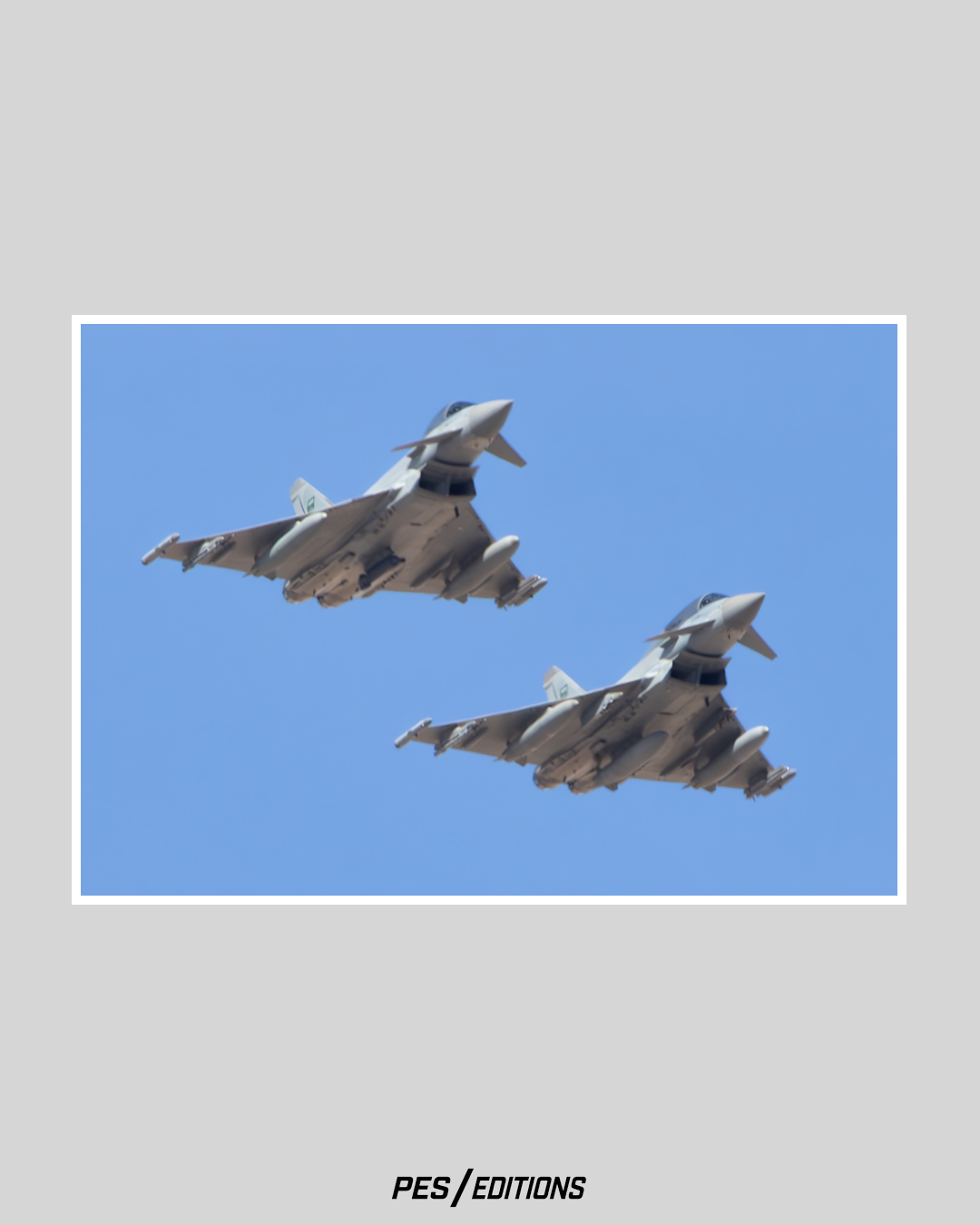 A pair of Eurofighter Typhoons flying in close formation. The delta-wing fighters are banking in unison against a clear blue sky.